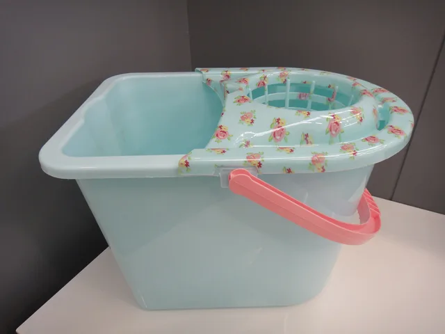 A light blue mop bucket with a patterned wringer and a pink handle. The startup budget for a home cleaning business and the ways to finance it without the jargon